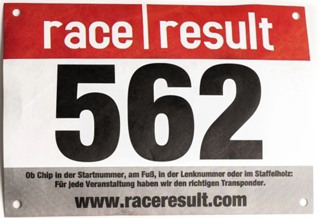 Front of a race bib numbered 562, printed with a note that the timing transponder may sit in the bib number, on the shoe, in the handlebar number or in the relay baton.